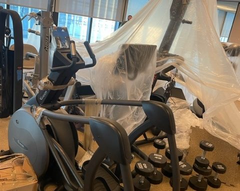 Gym equipment with protective plastic covers for sanitation and safety.