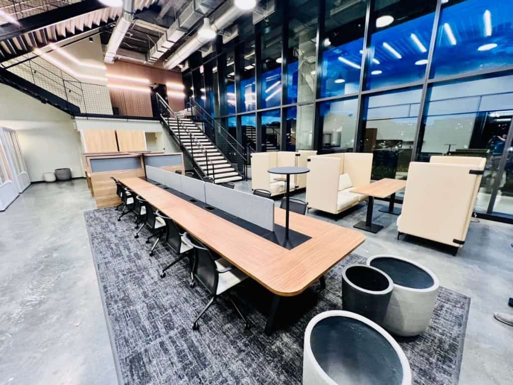 Modern corporate office interior with meeting area and lounge, featuring sleek furniture and large g.