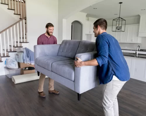 Two-men-moving-a-sofa-into-a-living-room
